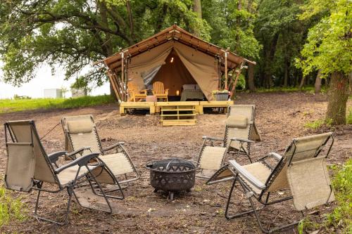 a group of chairs and a fire pit in front of a tent at Boutique Vineyard Stay at Painted Prairie in Currie