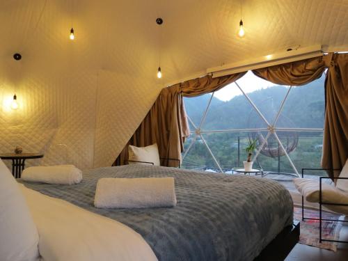 a bedroom with a large bed in a tent at Glamping Daphenili in Tskalt'ashua