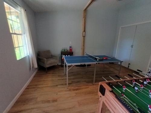a living room with a ping pong table in it at Pensacola hidden gem cottage 3 minutes from Navy Base, pet friendly in Pensacola
