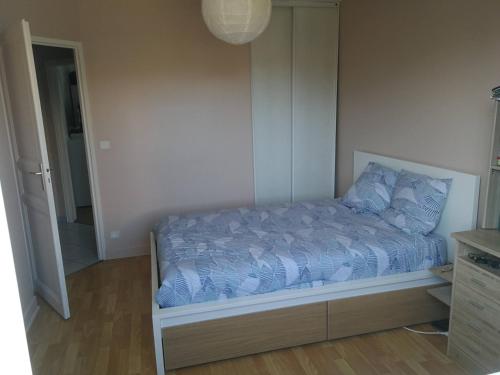 a bedroom with a bed with a blue comforter at Maison privée 106m2 avec 3 chambres et jardin in Saint-Médard-en-Jalles