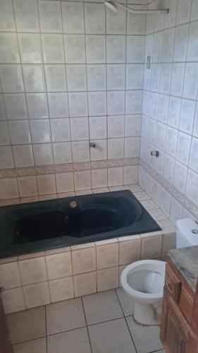 a bathroom with a bath tub next to a toilet at casacop30belem in Belém