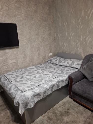 una camera da letto con un letto, un divano e una televisione di GRIG's home a Yerevan