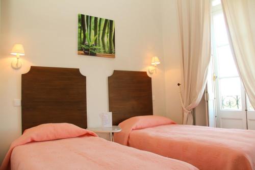 sypialnia z 2 łóżkami z pomarańczową pościelą i oknem w obiekcie Monte da Lua w mieście Sintra