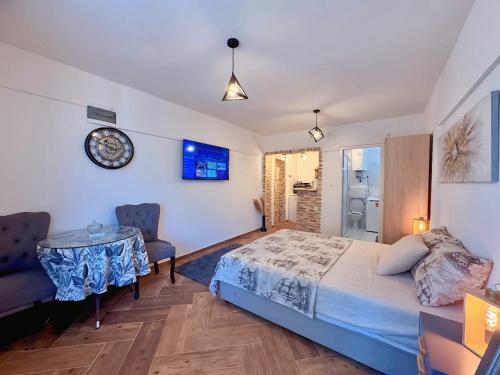 a bedroom with a bed and a table and a clock at Sunny Nest Studio Bar in Bar