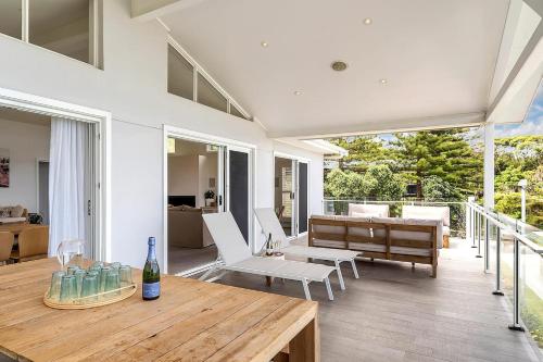 a living room with a table and a couch at Drift - Ocean & Panoramic Views At Coledale in Coledale
