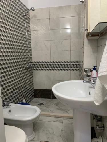 ein Badezimmer mit Waschbecken, Toilette und Dusche in der Unterkunft Auras in Vlorë