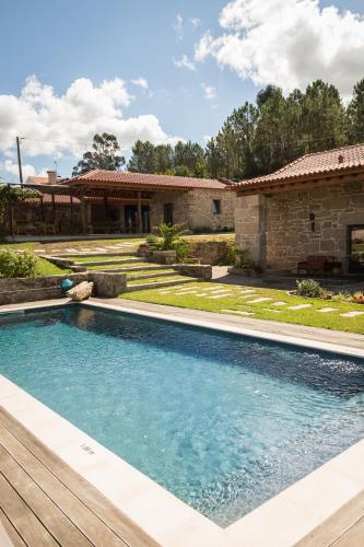 a swimming pool in a yard next to a house at Valados do Outeiro - Casas de Campo in Valença