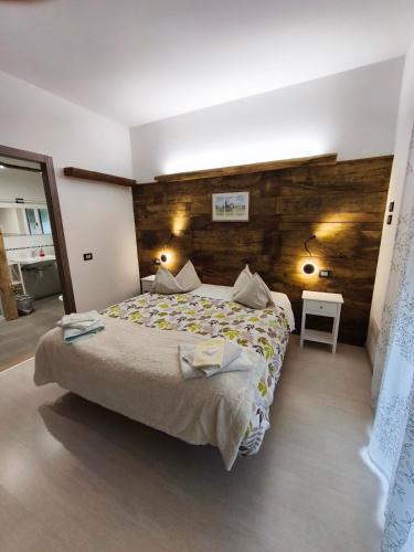 a bedroom with a large bed and a wooden wall at B&B Guglielmina in Quarna Sotto