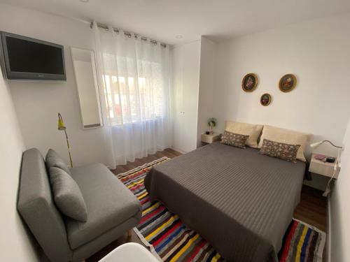 a bedroom with a bed and a couch at Casa da Covilhã - Pedra e Lã in Covilhã