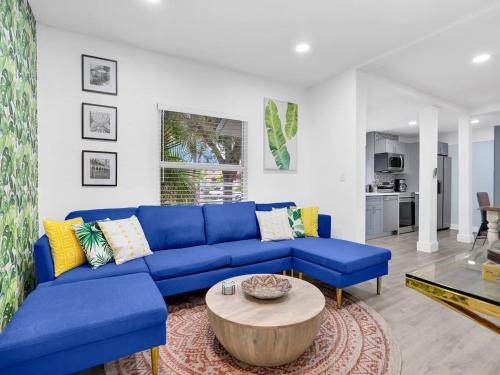 a living room with a blue couch and a table at Bungalow House 6 BR Pool Little Havana in Miami