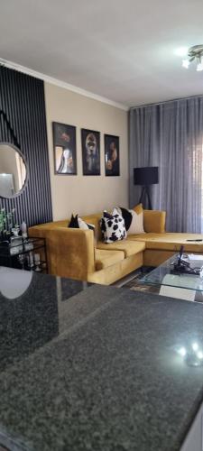 una sala de estar con un sofá y una mesa en Midrand apartment, en Vosburg
