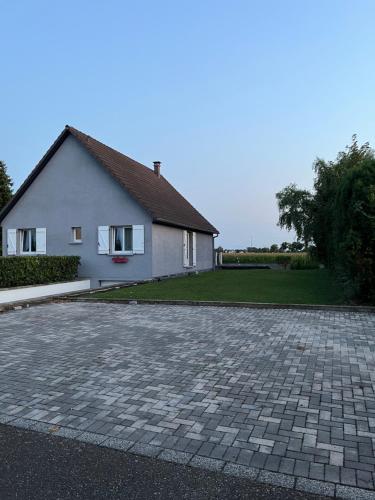 a house with a brick driveway in front of it at Au coeur du Ried 
