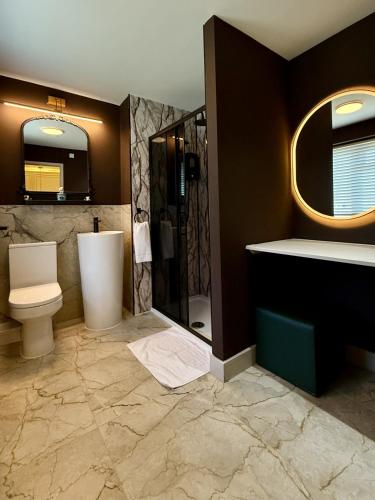 a bathroom with a toilet and a shower and a sink at Old Farm Hotel in Birmingham