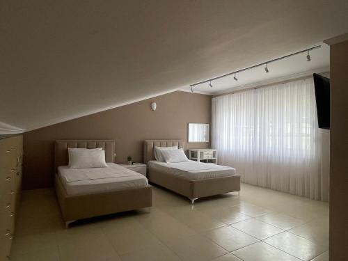 a bedroom with two beds and a television in it at Casa Di SI in Përmet