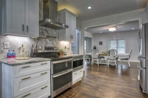 a kitchen with white cabinets and a dining room at Buckhead 8BR GetawayOpen Layout,Ideal for Groups in Atlanta