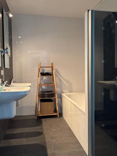a bathroom with a ladder next to a sink and a tub at Wellness Villa Binnenhof in Noordwijk