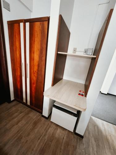 a room with a closet with a wooden door at Harbor Inn Jaraguá in Jaraguá do Sul