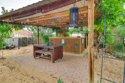 a patio with a wooden table and a wooden pergola at Outdoor Bar and Large Pool Retro ABQ Retreat! in Albuquerque