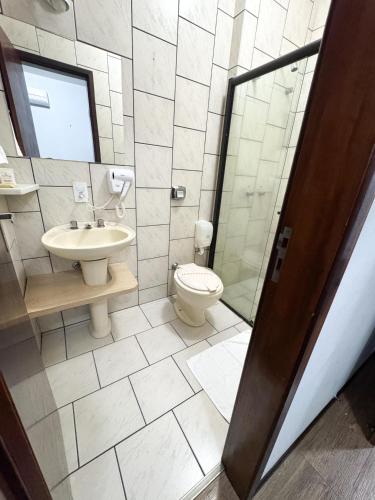 a bathroom with a toilet and a sink and a shower at Harbor Inn Jaraguá in Jaraguá do Sul