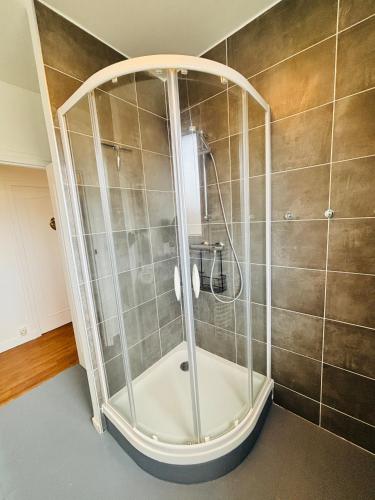a shower with a glass enclosure in a bathroom at Le Victor Hugo in Gien