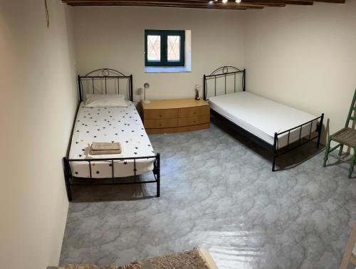 a room with two beds and a chair in it at Sunshine 1 in Leonidio