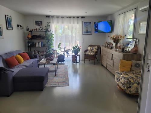 a living room with a couch and a tv at Vacances en Provence in Roquevaire