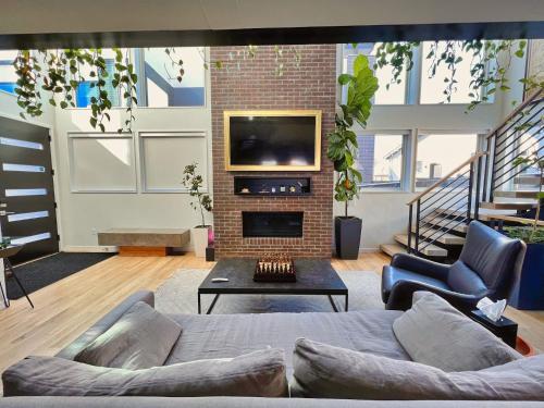 a living room with a couch and a tv at Modern Luxury Home I Sleeps 8 I 10min to Downtown in Denver