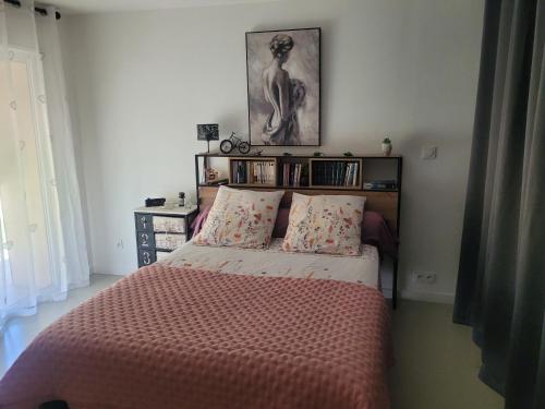a bedroom with a bed with a pink comforter at Vacances en Provence in Roquevaire