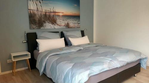 a bed in a bedroom with a painting on the wall at Neues Ruhrtal Apartment 3 mit Klimaanlage, Balkon in Wickede (Ruhr)