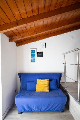 a blue bed in a room with a wooden ceiling at Duplex San Fedele in Como