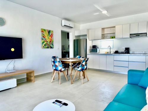 a living room with a table and chairs and a kitchen at Rheia Properties - SANTA FE in Sosúa