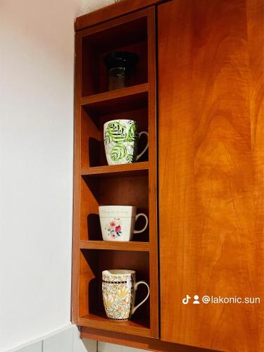 a wooden cabinet with cups in it at Lovely Apartment Lamia in Lamía