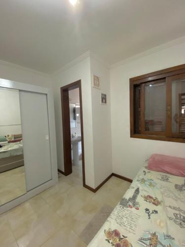a bedroom with a bed and a mirror and a bathroom at Duplex Acolhedor - Duas quadras do Mar Centro in Tramandaí