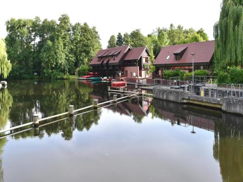 a body of water with a building and boats on it at Appartements mit Blick auf die Spree in Lübben in Lübben