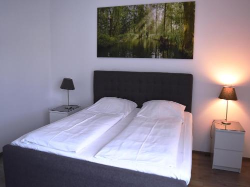 a bedroom with a bed with a painting on the wall at Appartements mit Blick auf die Spree in Lübben in Lübben