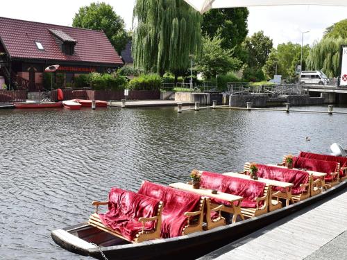 a boat with chairs and tables on the water at Appartements mit Blick auf die Spree in Lübben in Lübben