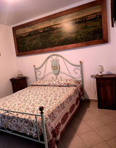 a bedroom with a bed with a painting on the wall at Agriturismo la Canonica in Manciano
