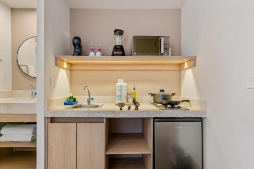a kitchen counter with a sink and a microwave at Ezequiel Montes By Homirent in Casa Blanca La Corregidora