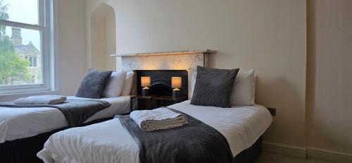 two beds in a room with a fireplace at Modern 2 bedrooms apartment in Town centre in Ipswich