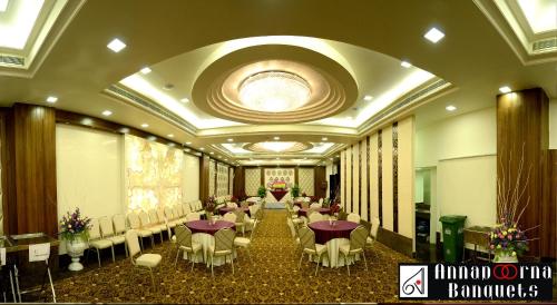 a banquet hall with tables and chairs in a room at Hotel Annapoorna Residency in Hyderabad