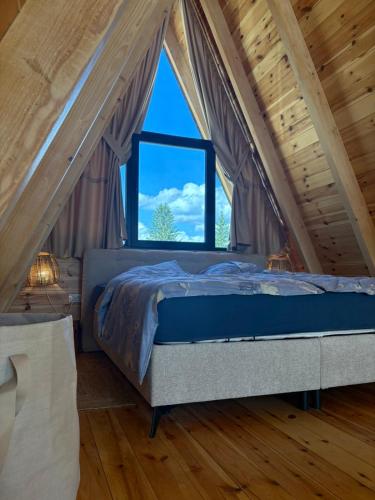 a bed in a room with a large window at Vista Montis in Žabljak