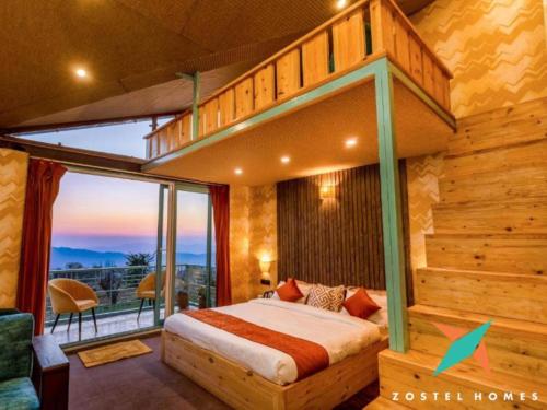 a bedroom with a loft bed with a balcony at Zostel Homes Bir in Bīr