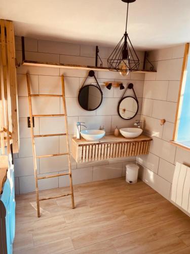 a bathroom with two sinks and two mirrors at GRANDE MAISON DE VACANCES SPa in Clairefougère