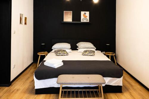a bed in a room with a black wall at Nordic Villa Brasov - With Private Yard, BBQ & Free Parking, 4 km from City Center in Braşov