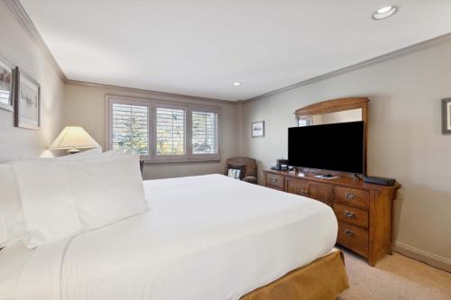 a bedroom with a large white bed and a flat screen tv at Lodge Tower 482 in Vail