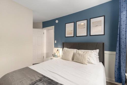 a bedroom with a large bed with blue walls at The Metropolitan Manor-new Corporate Apt Downtown in Grand Rapids