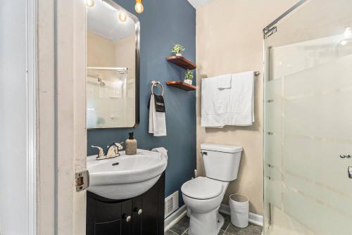 a bathroom with a white toilet and a sink at The Metropolitan Manor-new Corporate Apt Downtown in Grand Rapids