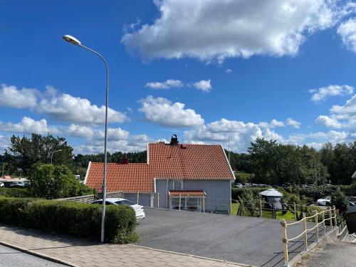 a house with a red roof in a parking lot at Havssnäckan - Nordic Stay Strömstad in Strömstad