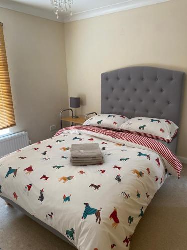 a bedroom with a bed with a dinosaur comforter at Hampton Ct River Thames village 1 bed maisonette in Thames Ditton