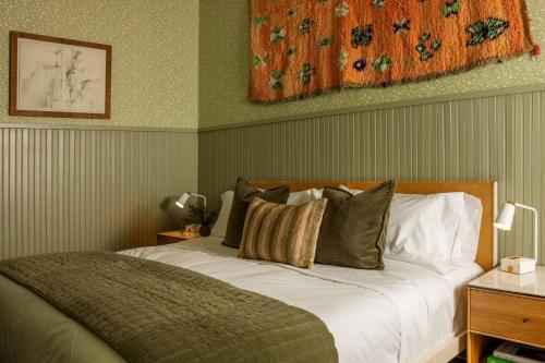 a bedroom with a large bed with green walls at The Carly Estate in Carlton